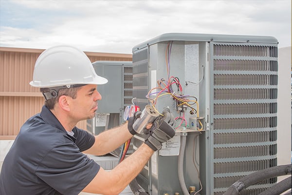 Webb Commercial HVAC Technician working on an AC unit on the roof of a North Carolina business helping you discover what type of heating system is most effective