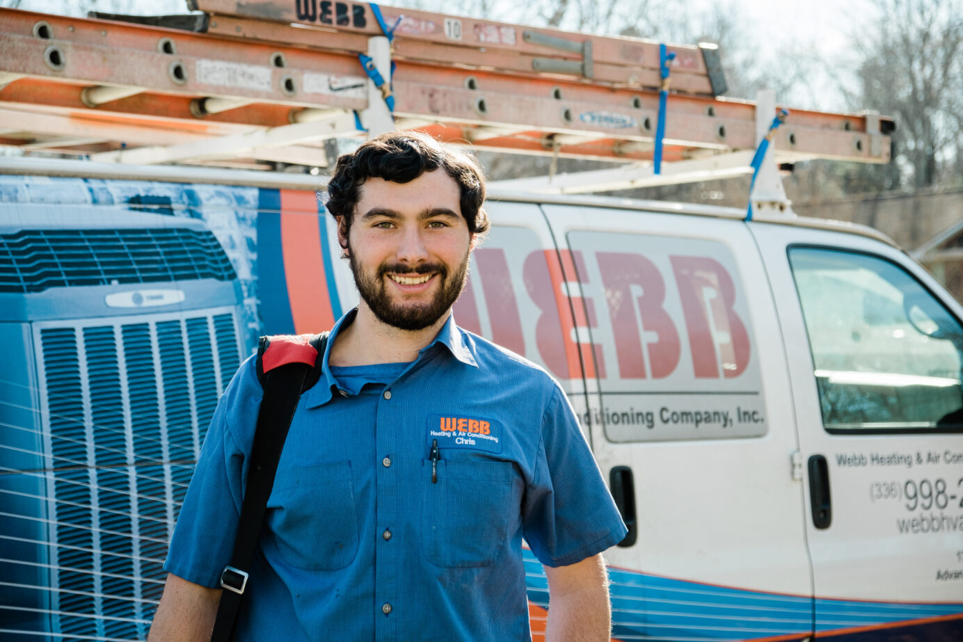Webb HVAC technician smiling in front of a Webb van in Greensboro, North Carolina